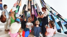Ewa Kokot opowiada grupce dzieci o kolażu prezentowanym na wystawie w Galerii Ściana Sztuki Dziecka