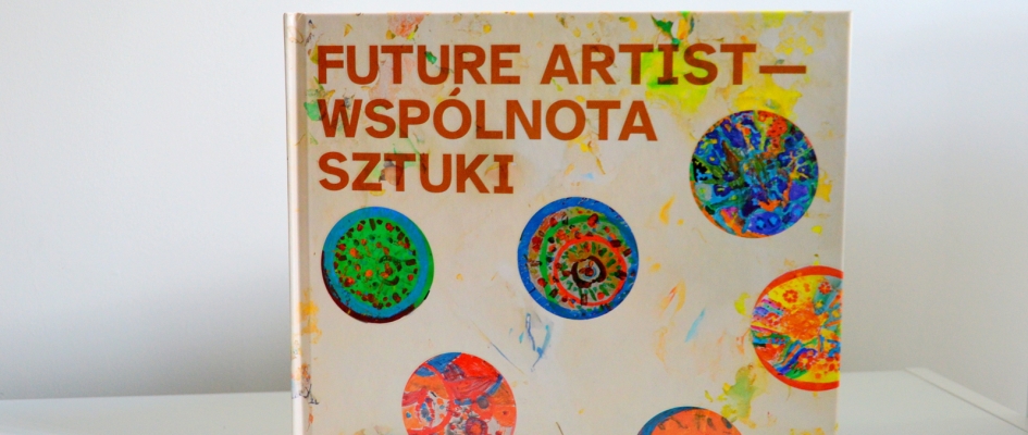 Na zdjęciu książkowa wersja publikacji Wspólnota sztuki. Na okładce książki tytuł oraz kolorowe abstrakcyjne okrągłe obiekty namalowane przez uczestników warsztatów